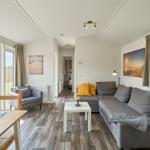 Wohnbereich mit Sofa, Esstisch und Blick auf Garten