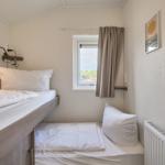 Zimmer mit zwei Betten, Fenster und Wandbild.