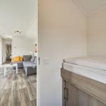 Schlafzimmer mit Bett und Blick in Wohnbereich mit Sofa und Tisch