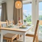 Essbereich mit Tisch, Stühlen und Blick auf Terrasse.