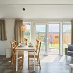 Essbereich mit Tisch und Stühlen, Sitzgelegenheit und Terrassentür.