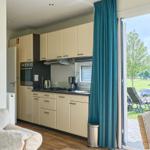 Küche mit Essbereich und Terrasse mit Blick auf Grünflächen.