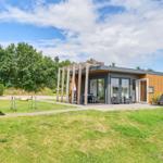 Moderne Ferienwohnung mit Terrasse, Garten und Sitzgelegenheiten unter freiem Himmel.
