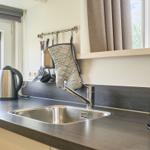 Küchenzeile mit Spüle, Kaffeemaschine und Wasserkocher.