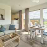 Wohn- und Essbereich mit Blick auf die Terrasse und Grünfläche.