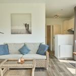 Wohn- und Essbereich mit Sofa, Tisch und Küchenbereich.