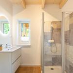 Badezimmer mit Dusche, Waschbecken und Fenster