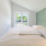 Schlafzimmer mit Bett, Fenster und Wandbild