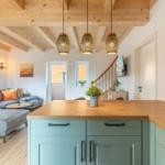 Küche mit Holzwerkzeug und Wohnbereich mit Sofa und Treppenhaus.