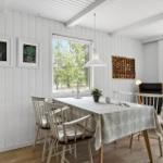 Esszimmer mit Tisch, Stühlen und Fenstern zur Außenseite.