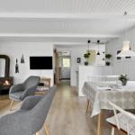 Wohn- und Essbereich mit Kamin, TV und Tisch mit Stühlen.