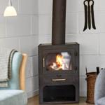 Holzofen mit brennendem Feuer in einem Raum mit weißen Ziegelwänden und Sitzgelegenheiten.