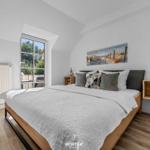 Schlafzimmer mit Bett, Fenster und Wandbild