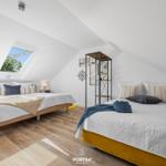 Zwei Betten unter Dachschrägen mit Blick auf den Himmel.