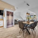 Küche, Essbereich und Wohnzimmer mit Holzboden und moderner Einrichtung.