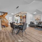 Wohn- und Essbereich mit Holzboden, Sofa und Esstisch.