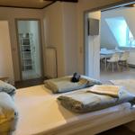 Schlafzimmer mit Doppelbett, angrenzender Küche und Bad.