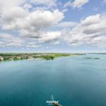 Aerial view of a coastal town with boats and greenery.
