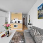 Wohn- und Küchenbereich mit Sofa, Tisch und Wandbild.