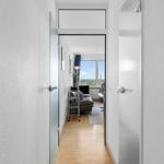 Flur mit Holzboden führt in Wohnzimmer mit Blick auf Stadt.