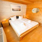 Schlafzimmer mit Holzwand, Bett, Nachttisch und Spiegel