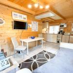 Wohnbereich mit Küche, Esstisch und Sofa in Holzhaus