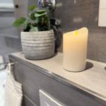 Badezimmer mit Pflanze, LED-Streichhölzer und modernem Waschbecken.