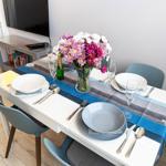 Esstisch mit Stühlen, Blumenvase und Geschirr.