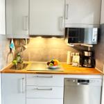 Küche mit Spüle, Mikrowelle, Kaffeemaschine und Geschirrspüler.