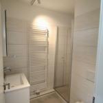 Badezimmer mit Dusche, Toilette und Waschbecken.