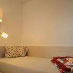 Schlafzimmer mit Bett, Kissen und Stehlampe.