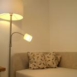 Beleuchtete Ecke mit Sofa und Stehlampe.