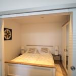 Schlafzimmer mit Doppelbett, Nachttischen und Wandbild.