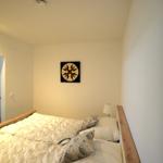 Schlafzimmer mit Bett, Wandbild und Nachttisch