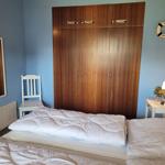 Schlafzimmer mit Doppelbett, Kleiderschrank und Nachttisch.