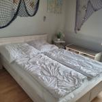 Schlafzimmer mit Bett, Nachttisch und Fenster