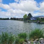 Häuser am Wasser mit Bootsstegen und Grünflächen.