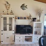 Wohnzimmer mit TV, Schrank und Dekoration.