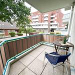Terrasse mit Tisch, Stühlen und Blick auf Wohnhaus und Grünflächen