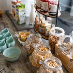 Frühstückstisch mit Getränken, Müsli und Porridge in Gläsern