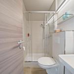 Badezimmer mit Dusche, Toilette und Waschbecken.