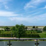 Blick von Balkon auf grüne Flächen und Himmel