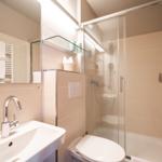 Badezimmer mit Dusche, Waschbecken und Toilette.