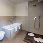 Badezimmer mit Badewanne, Dusche und Toilette.