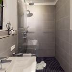 Badezimmer mit Dusche, Waschbecken und Handtuchhalter