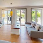 Wohnzimmer mit Sofa, TV und Terrassenzugang