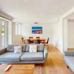 Wohn- und Essbereich mit Sofa, Tisch und Stühlen.