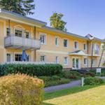 Ein gelbes Haus mit Balkon und Gartenweg.