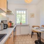 Küche mit Essbereich, Fenster, Arbeitsplatte und Küchengeräten.