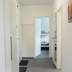 Flur mit Schlafzimmer und Kleiderhaken. Wandbild und Steckdose sichtbar.